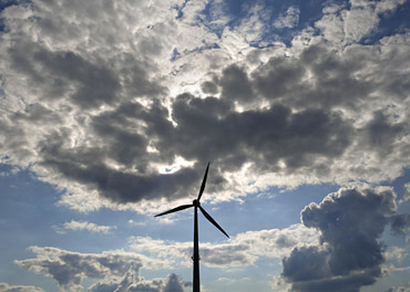 Foto mit einem Windrad vor einem wolkigen Himmel