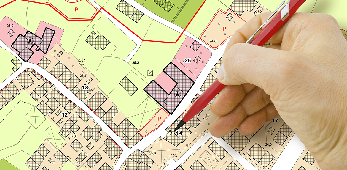 Hand zeigt mit Stift auf einen Wärmeplan
