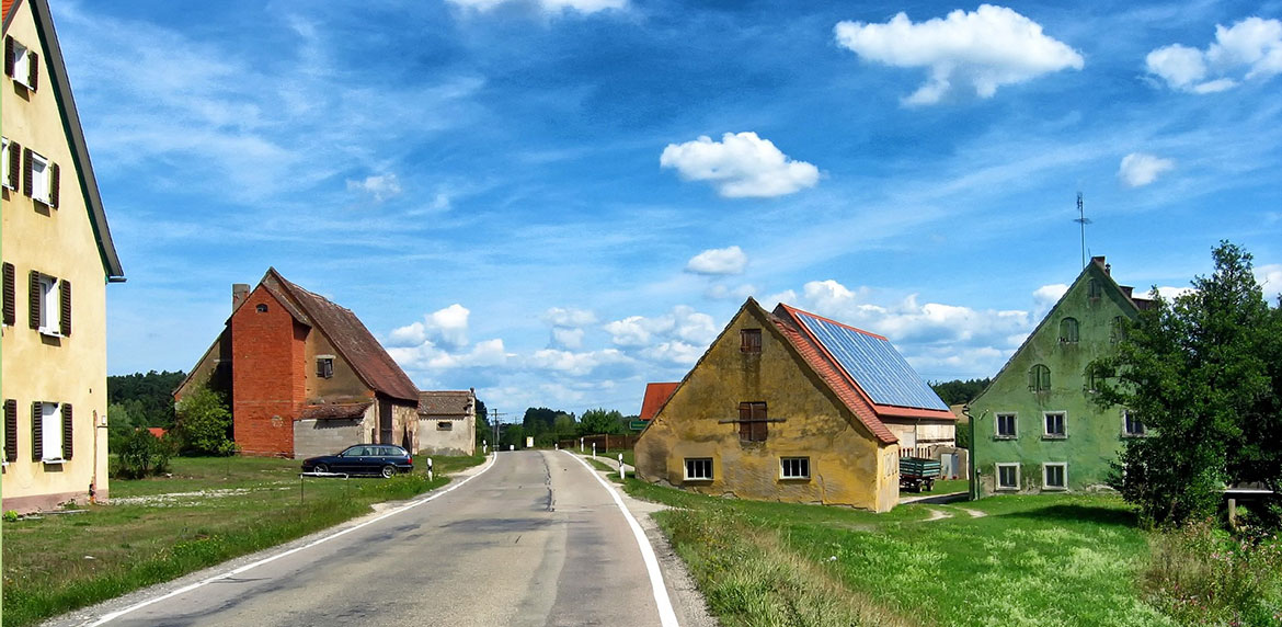 Eine Häuserreihe. In der Mitte des Bildes verläuft eine Straße.